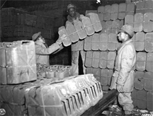 Red Ball Express troops stack "jerry cans" used to transport gasoline to front-line units during World War II.