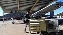 An aircraft armament technician pushes a 500-pound toolbox to an A-10 at Whiteman Air Force Base