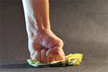 A fist crushing a small cardboard container