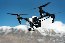 A drone carrying a camera, flying under remote control