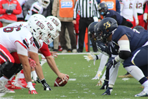 Two football teams face off at the line of scrimmage