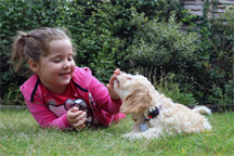 A young girl and a puppy having a moment together