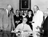 U.S. President Franklin D. Roosevelt signs the Social Security Act, 13 August 1935