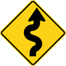 A USA road sign indicating a winding road ahead, with an initial curve to the right