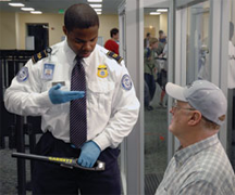 A TSA Officer screening a passenger